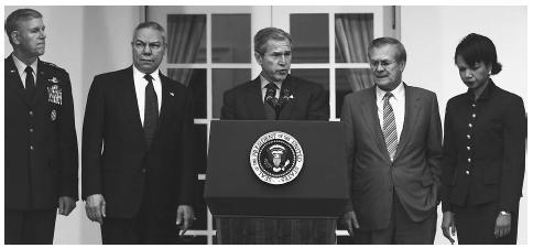 With his national security team assembled in the Rose Garden at the White House, President Bush, center, announces that the United States will withdrawl from the 1972 Anti-ballistic Missile Treaty in 2002, paving the way for the development of a defensive anti-ballistic missile technology program. AP/WIDE WORLD PHOTOS.