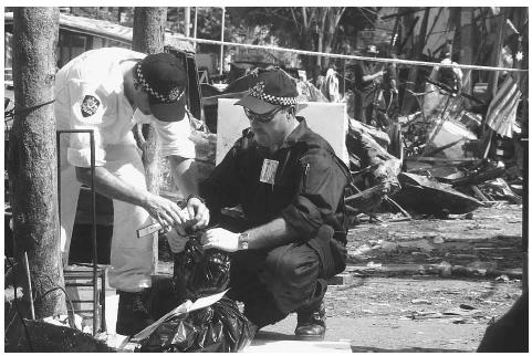 An Australian forensic team collects evidence at the bombing site of a nightclub in Kuta, Bali, that killed nearly 200 people. Suspects arrested for the bombing claimed to be members of the Jemaah Islamiyah regional network, an ally of Osama bin Laden's Al Qaeda. AP/WIDE WORLD PHOTOS.