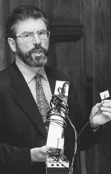 Sinn Fein President Gerry Adams dsiplays an electronic tracking and listening device, found in a car used by Sinn Fein leaders, during a press conference in Belfast, Northern Ireland in 1999. AP/WIDE WORLD PHOTOS.