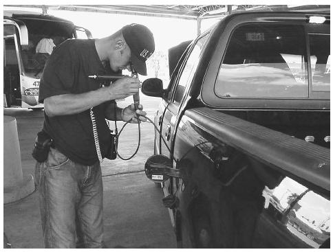 A supervisor with the Bosnia-Herzegovina State Border Service Agency uses a fiberscope to examine the gastank of a pickup truck during the International Border Interdiction Training conducted by the U.S. Customs Service at the Hidalgo port of entry in Hidalgo, Texas. AP/WIDE WORLD PHOTOS.