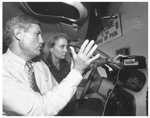 A United States Customs official, right, receives instruction on LoJack, a technology that utilizes GPS, intended to help recover stolen cars before they are smuggled out of the United States. AP/WIDE WORLD PHOTOS.