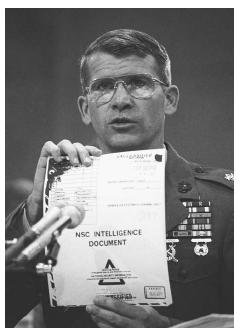 Lt. Col. Oliver North holds up a National Security Council intelligence document marked "TOP SECRET" during testimony before the House-Senate investigating committee at the Iran-Contra hearings in Washington, D.C., 1987. AP/WIDE WORLD PHOTOS.