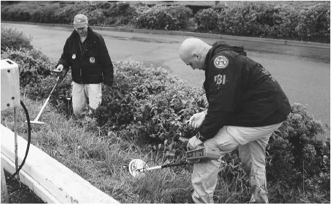 FBI agents use metal detectors to search for evidence in a series of sniper attacks that occurred in the Washington, D.C., area in 2002. AP/WIDE WORLD PHOTOS.