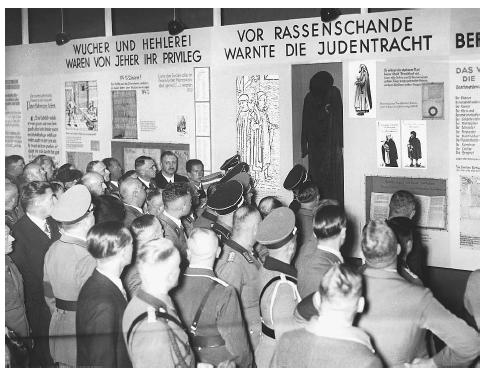 A crowd of people read the displayed information at the Nazi propaganda exhibition in Munich, Germany, in 1937. ©HULTON-DEUTSCH COLLECTION/CORBIS.