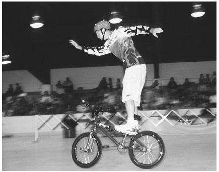A young man shows off his skills at an extreme bike-riding exhibition. (Photograph by Robert J. Huffman. Field Mark Publications. Reproduced by permission.)