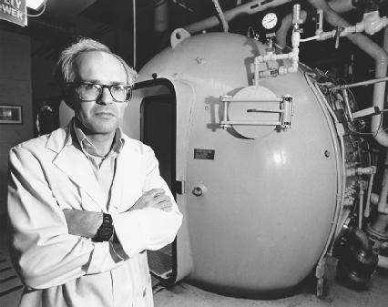 Dr. James M. Clark is standing in front of a hyperbaric chamber treating a patient for decompression sickness. (Reproduced by permission of AP/Wide World Photos)