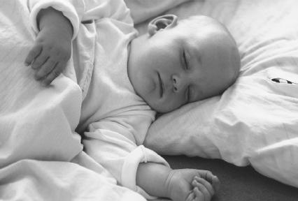 Experts now suggest that babies sleep on their backs or their sides. In these positions, they are less likely to have their faces covered in pillows and blankets. (© 1993 Jan Halaska. Reproduced by permission of Photo Researchers, Inc.)