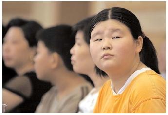 Young Chinese attend a weight-loss lecture in Shanghai. A trend toward obesity in many nations is accompanied by obsession over body image. During 2002, several citizens of Asian nations died and hundreds were sickened when they took a popular diet pill that was known to cause health problems. [AP/Wide World Photos. Reproduced by permission.]