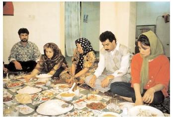 What and how people eat is determined by a variety of factors, including economic circumstances, cultural norms, and religious restrictions. Here, an Iranian family sits on the floor and eats from a cloth laden with regional delicacies. [Photograph by Earl and Nazima Kowall. Corbis. Reproduced by permission.]