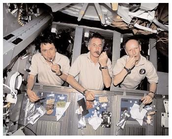 Astronauts on the International Space Station prepare to share a meal. The quality of their menu contrasts sharply with those of the early space explorers, whose meals were either semi-liquids—squeezed from a tube—or bite-sized cubes. [NASA. Reproduced by permission.]