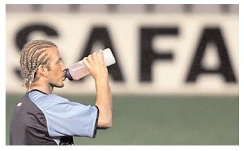 Water facilitates a number of critical body functions, from lubricating joints to carrying away cellular waste. Physical activity speeds fluid loss via perspiration. Athletes who do not drink enough water can easily become dehydrated, which can impair physical and mental functioning. Here, soccer star David Beckham drinks from a water bottle during a practice session. [AP/Wide World Photos. Reproduced by permission.]