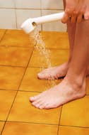 Place the showerhead about half a foot away from your left foot